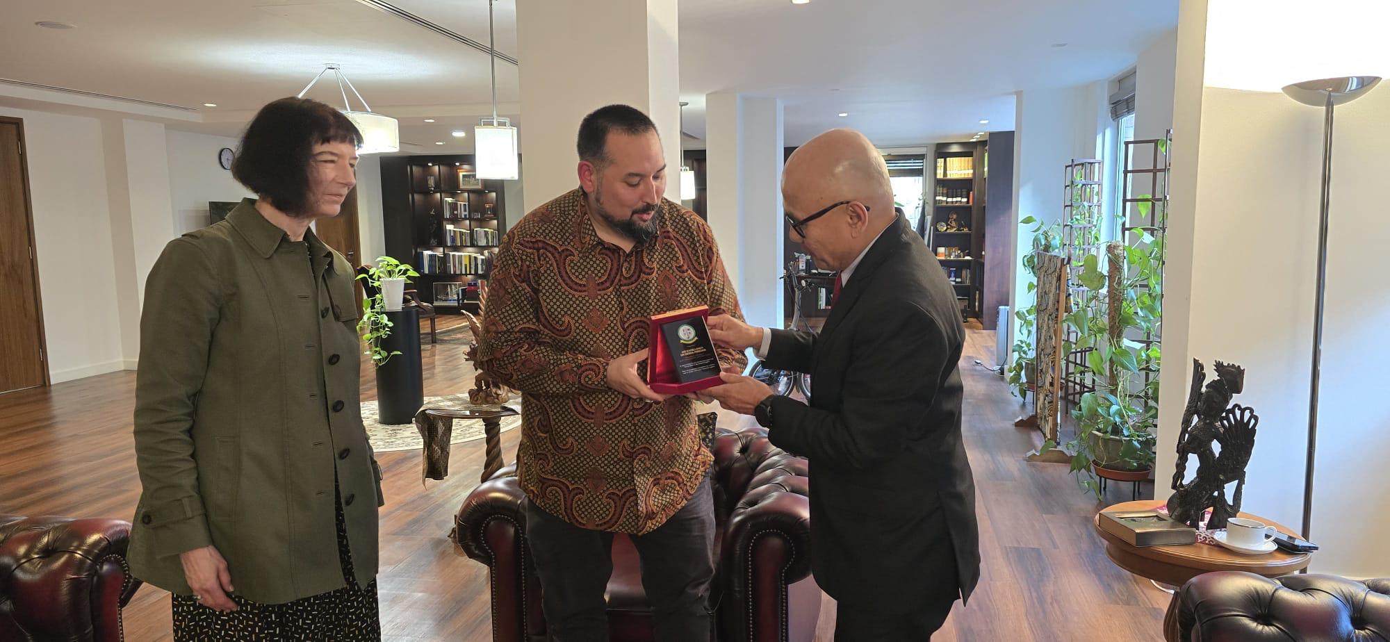 Irfan Al Rashid presenting a plaque to the Ambassador of Indonesia